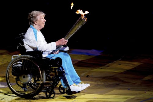Margaret Maughan holding the lit Paralympic Torch at the London 2012 Paralympics opening ceremony