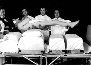 A patient being lifted and turned to avoid getting more bed sores.