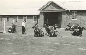 A group of people playing wheelchair hockey outside Stoke Mandeville in the 1940s