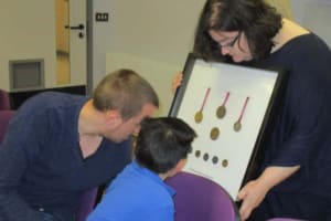 Children and teachers at Booker Park special school looking  at Paralympic medals