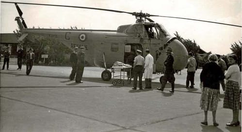 Black and white photo of the first patient arriving by RAF helicopter at Stoke Mandeville Hospital.